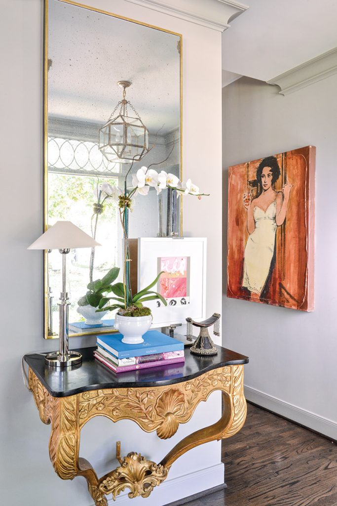 In the foyer, a gold console from Shabby Slips greets guests with a simple and thoughtful vignette (one of Goforth’s signatures), while an abstract painting by Adele Sypesteyn leads the way into the living area.