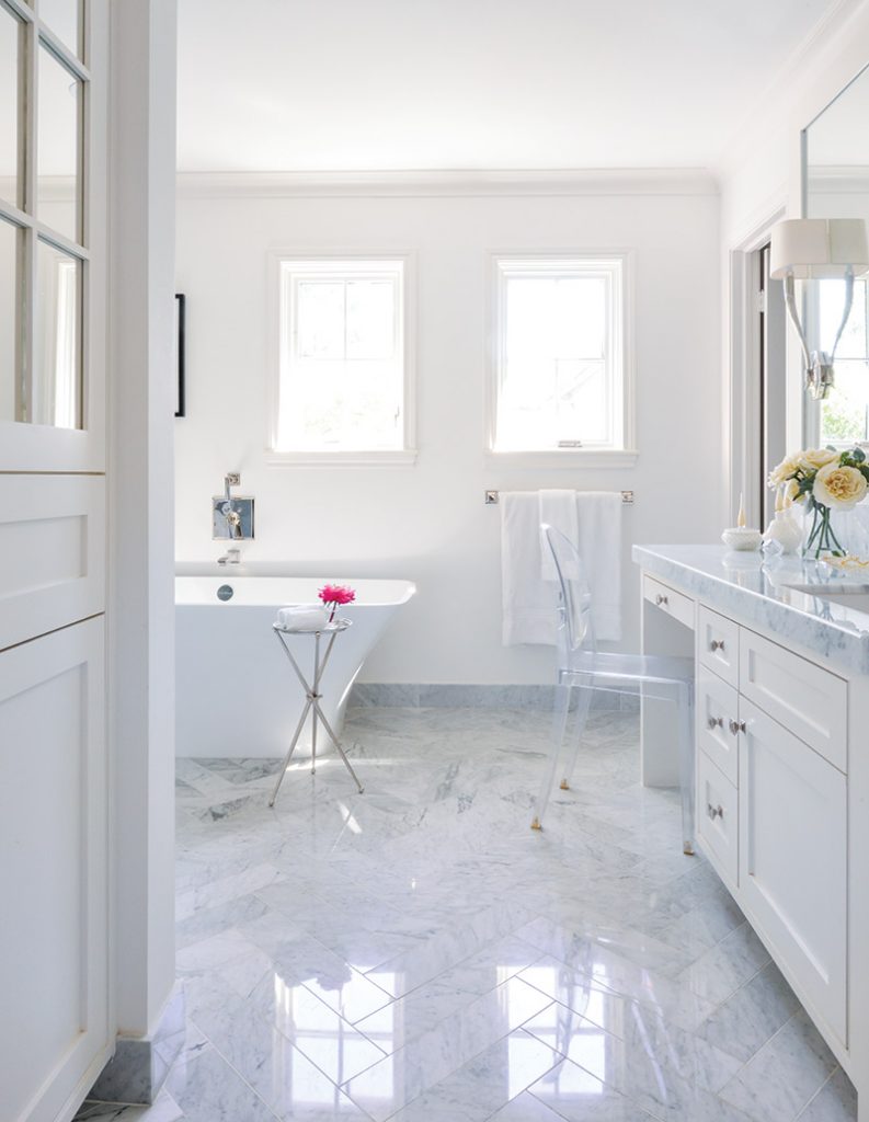 White marble bath with a freestanding tub and a long double vanity