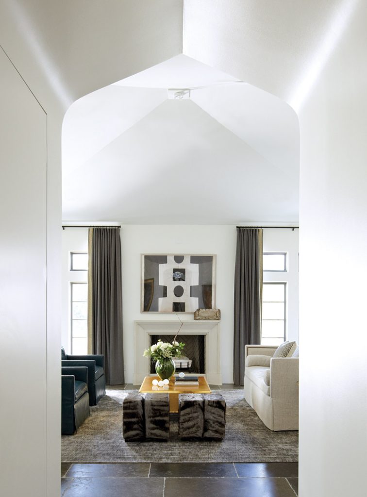 White barrel-vaulted hall opening onto a sitting room and fireplace