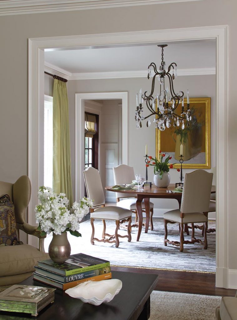 View through a doorway to a dining room with a chandelier and hydrangeas