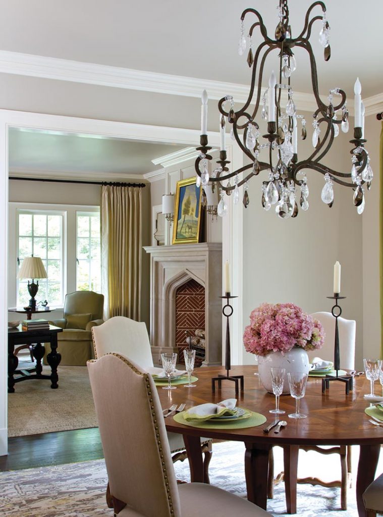 Dining room with a wrought-iron chandelier, pink hydrangeas and an arched niche