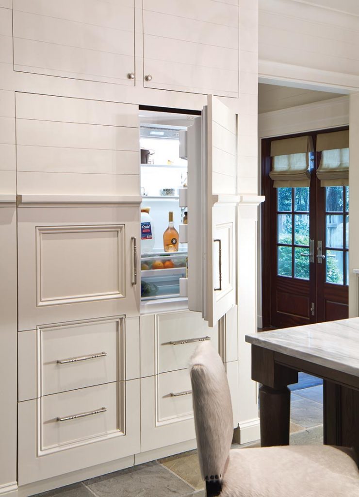 The design team used shiplap siding and generous moldings to give the kitchen a textured, handcrafted feel.