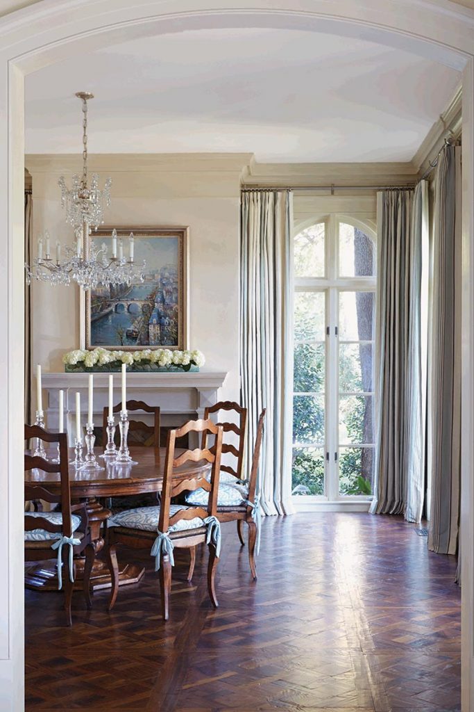 In the dining room, curtains are a silk stripe by Manuel Canovas. The cushions are by Cowtan & Tout. Walnut parquet floors are left bare to show off their rich pattern.