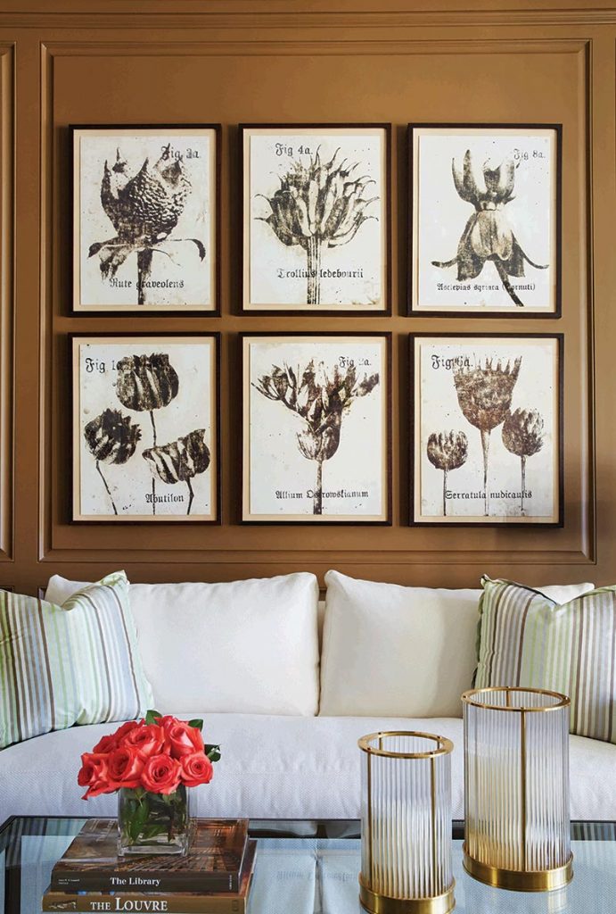 In the library, Phillips painted the wood paneling a warm brown and filled the room with white and green upholstery for a clubby but not oppressive atmosphere.