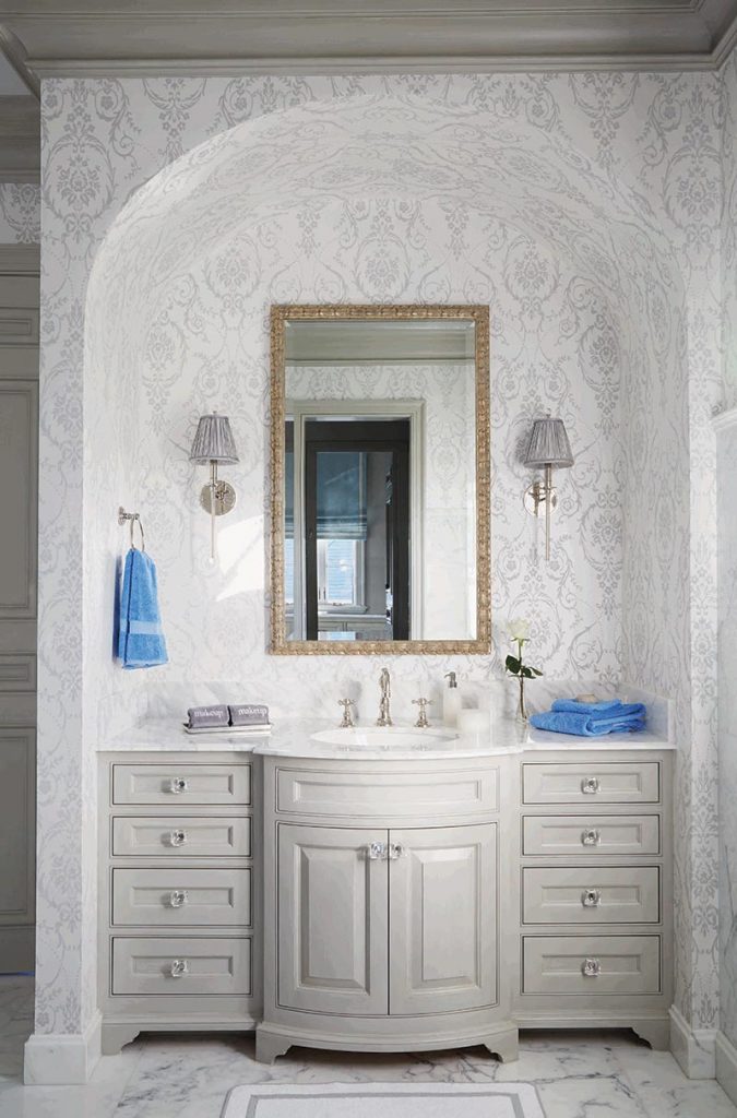 In the bathroom, a tone-on-tone damask echoes the veining of the marble floors and walls.