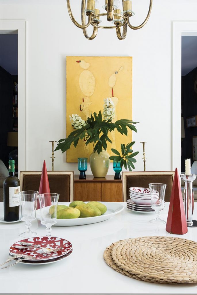 A canvas by Colombian artist Mauricio Luengas inspired the dining room’s palette of gold and red accents.