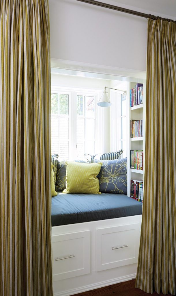 A cozy reading nook with built-in bookcases, a daybed, and efficient storage make a practical and fun kid-friendly sanctuary. The curtains are from Tracery’s line of signature fabrics.