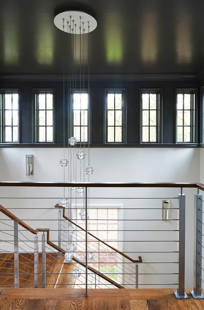 At the end of the hall, a contemporary stairway ascends to a second floor with children's bedrooms and a media playroom.