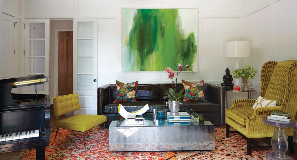 Living room with a black grand piano, chartreuse chairs and a green abstract painting