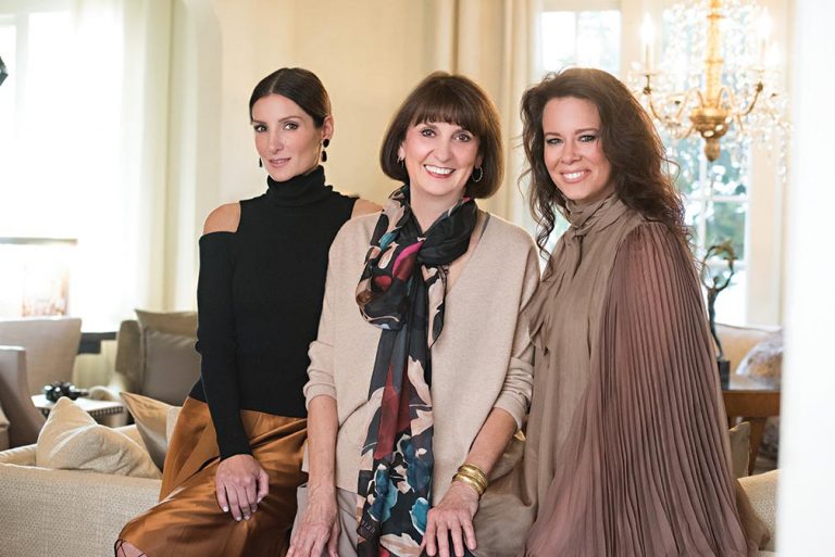 Portrait of three of the firm's designers seated on a cream sofa