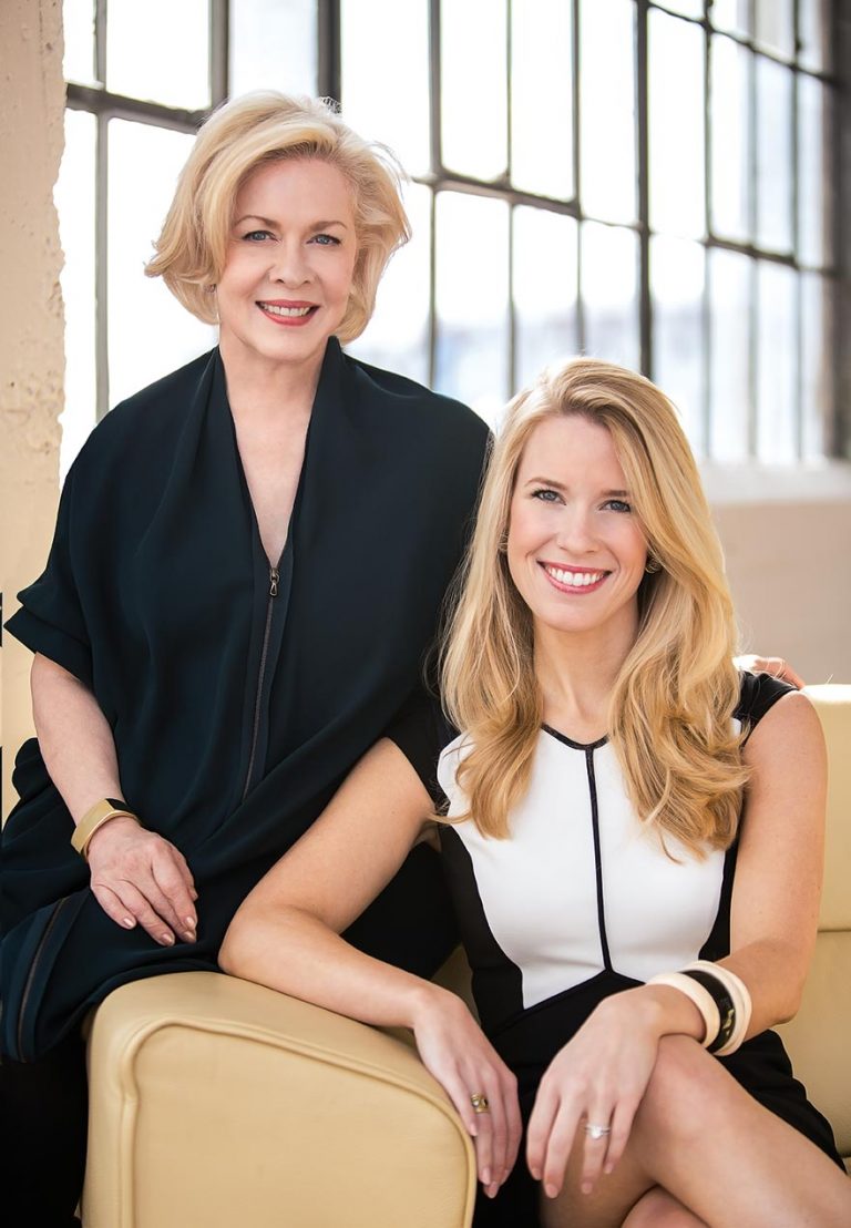 Portrait of the two featured designers in front of a black steel window