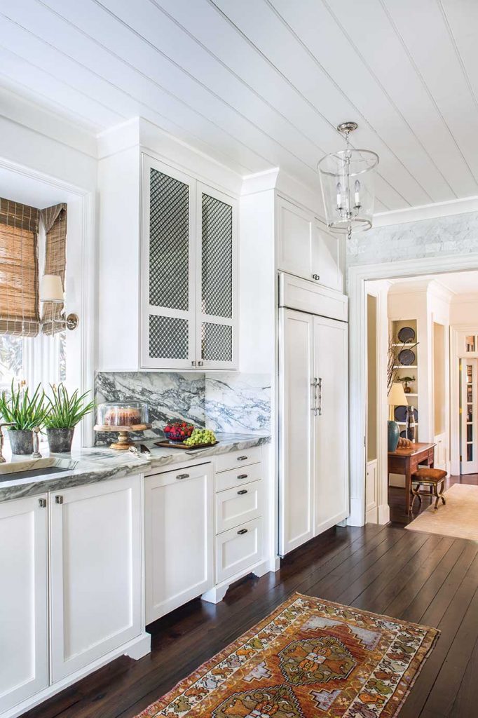 Minimal changes in the kitchen included a fresh coat of paint in a soft shade of white that works well with the marble.