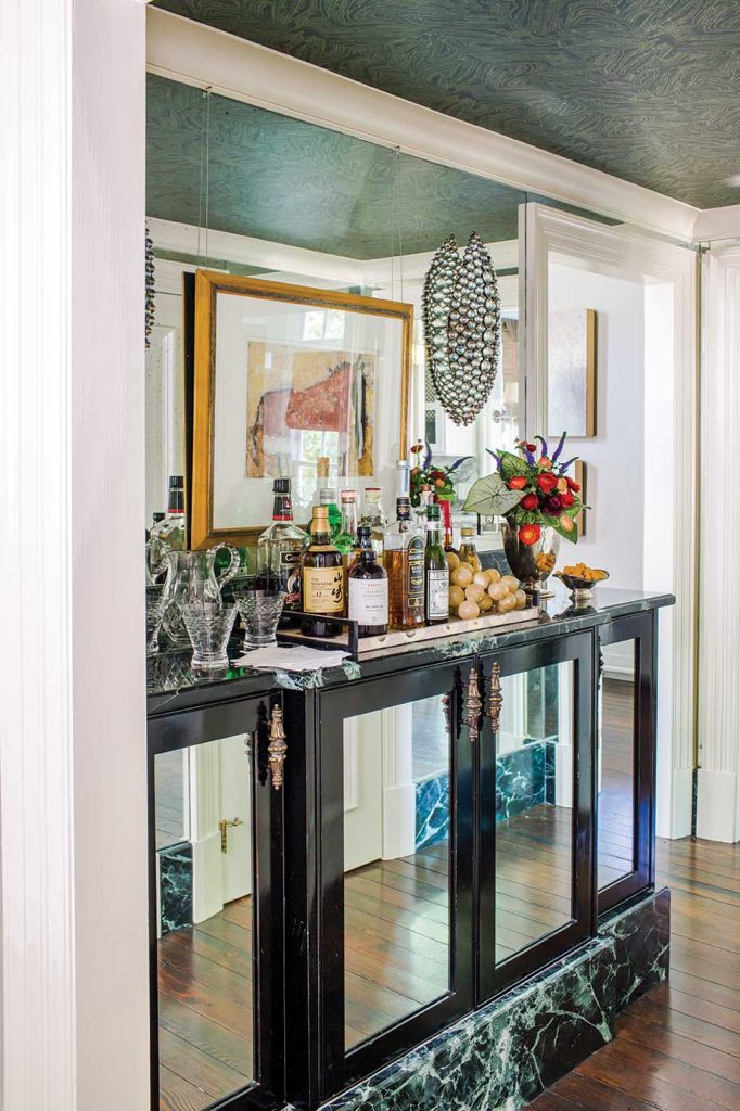 A built-in bar with mirrored accents and glass orb sconces set in brass makes a sophisticated statement.