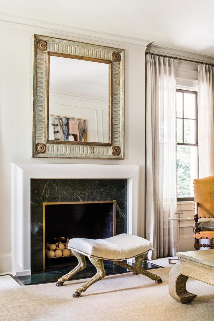 In the living room, an Italian antique horse-hoof bench contrasts with a contemporary ceramic-ball fireplace.