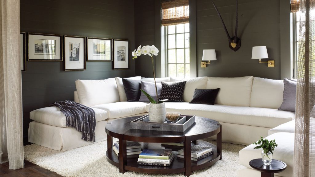 A slipcovered sofa and a round cocktail table soften the room.
