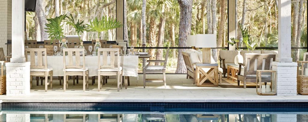 A lavish dining cabana is furnished with Restoration Hardware’s outdoor collection. Natural textures and white tableware echo the interior palette.