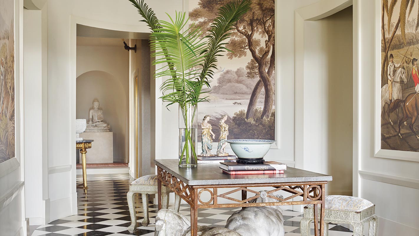 Hall with a painted landscape mural, a tall palm and a marble checkerboard floor