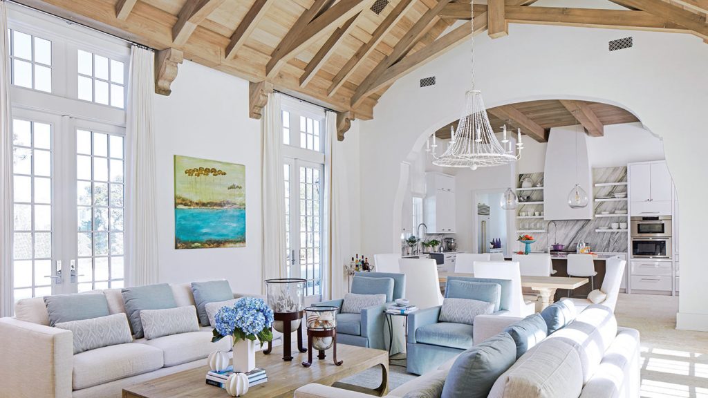 Living room with a timber vaulted ceiling, white sofas and blue hydrangeas