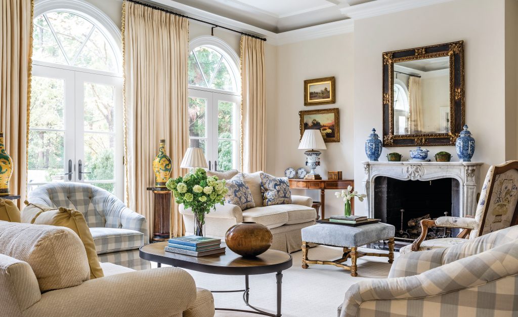 Living room with arched windows, a gilt mirror and cream upholstery