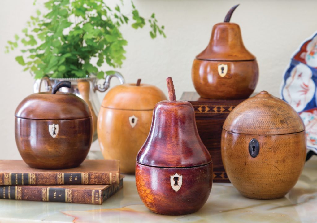 Group of turned wood tea caddies and lidded jars on stacked books