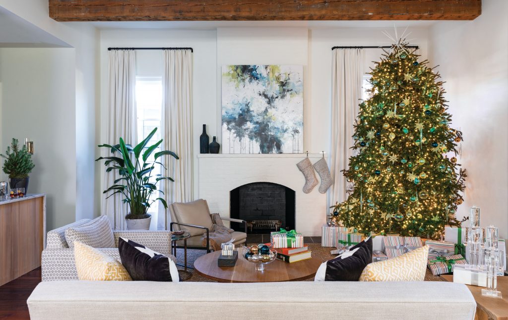 White living room with exposed beams, a lit tree and pale seating