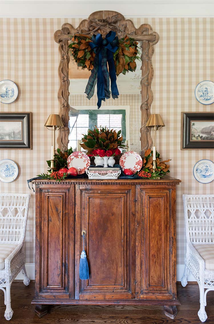 Antique cabinet with a bow-tied wreath and blue-and-white plates around it