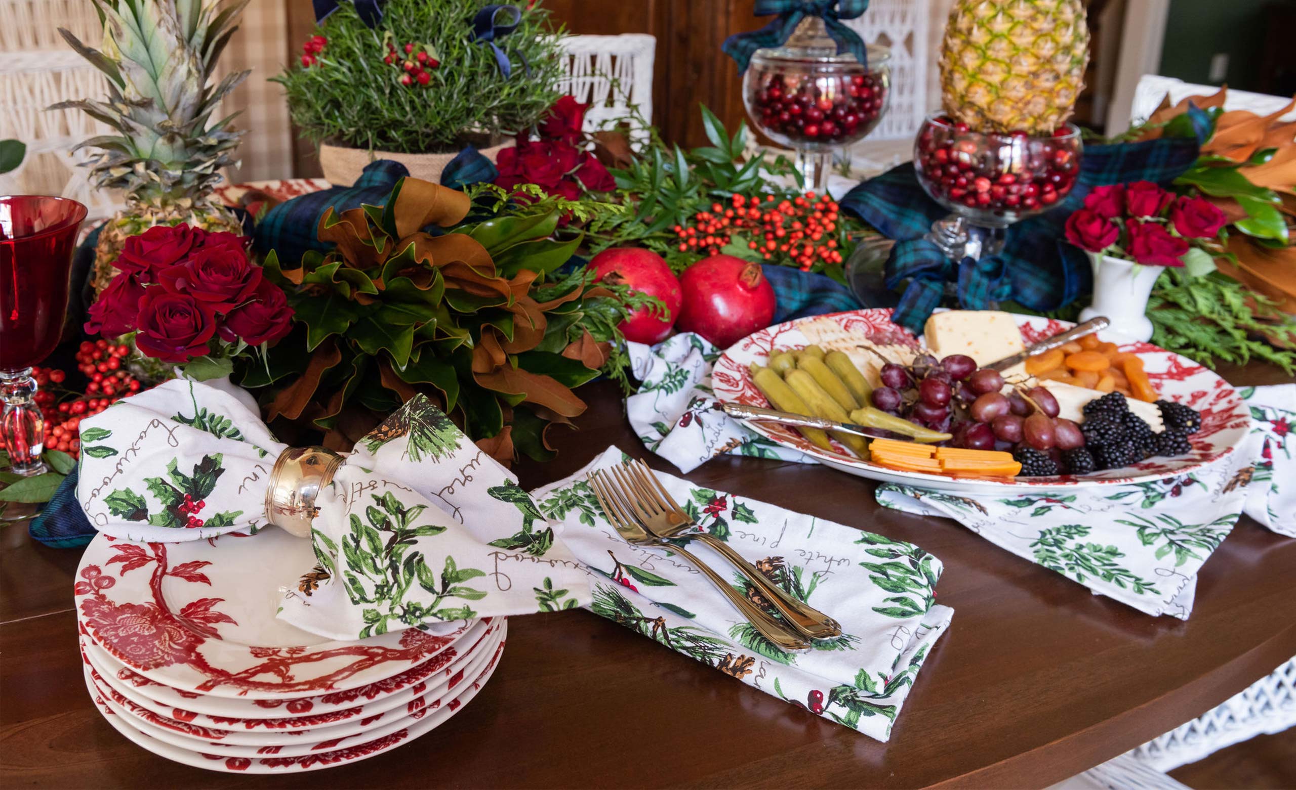Holiday table with magnolia, pomegranates and red toile plates