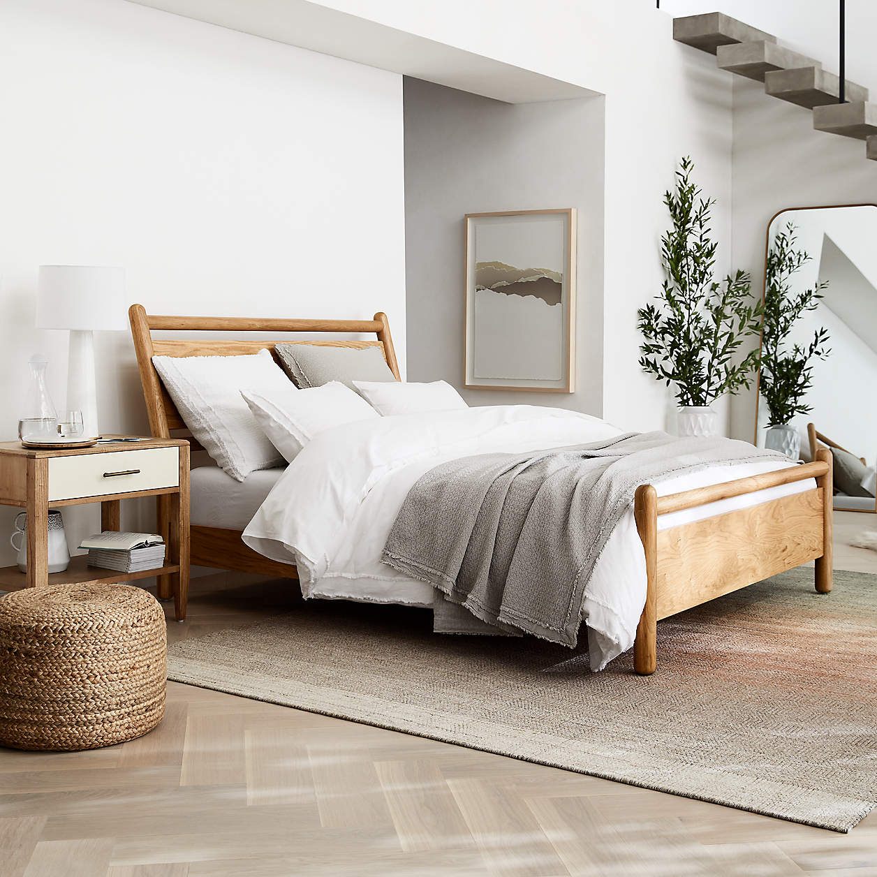 Bedroom with a cane bed, woven stools and a neutral rug