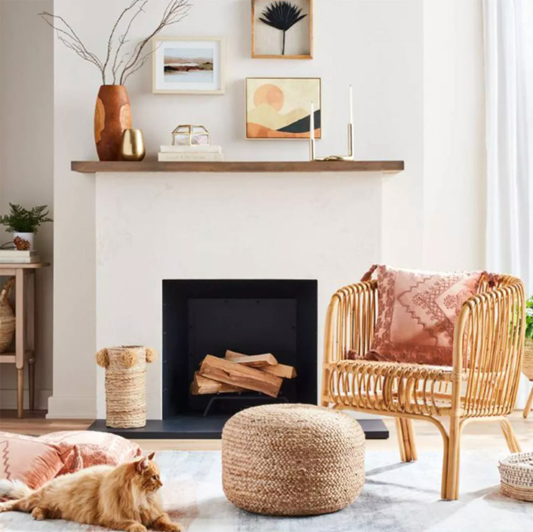 Plaster fireplace with a rattan chair, ceramics and a woven pouf