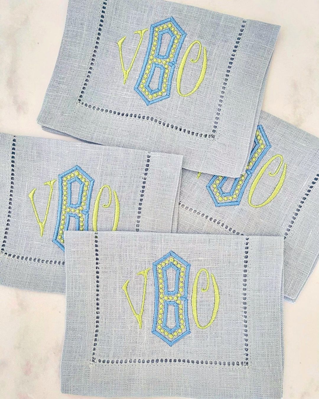Four monogrammed pale blue linen cocktail napkins