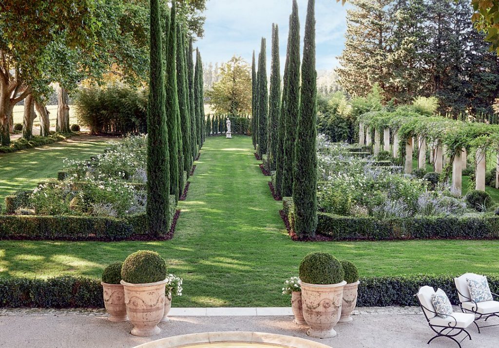 Cypress-lined lawn with clipped hedges and terracotta pots