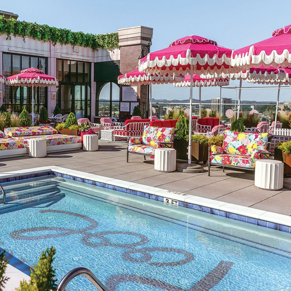 Hotel pool with pink scalloped umbrellas and floral cushions