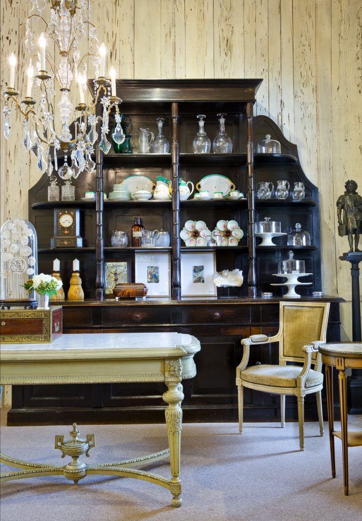 Dining room with a china cabinet, gilt chairs and a crystal chandelier