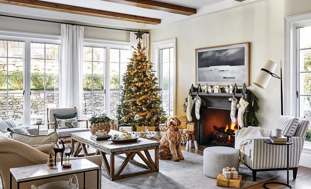 Goldendoodle Archie warms himself by the fire. A Scandinavian flavor reigns over the Christmas decor, while 8-foot casement windows fill the room with winter sunshine.