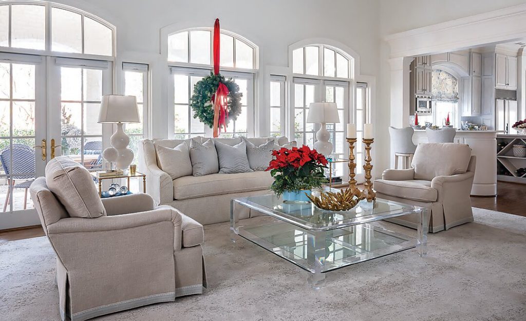 Living room with slipcovered seating, a wreath and poinsettias