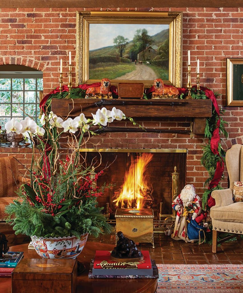 Brick fireplace with garland, amaryllis and a landscape painting above
