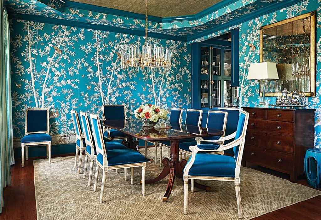 In the dining room, a set of chairs brought from the owners’ previous residence was the jumping off point for the teal palette. They are complemented by a botanical Schumacher wallcovering and neutral grasscloth on the ceiling. Polished accents add to the room’s refined yet current feel.