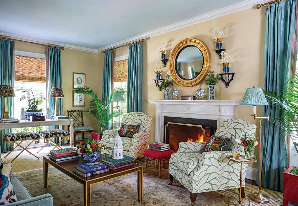 A green lacquered door adds a punch of color to the inviting foyer. Windows flood the living room with natural light while a soft blue ceiling perfectly complements the furnishings. A former dining room table was transformed to a console table.