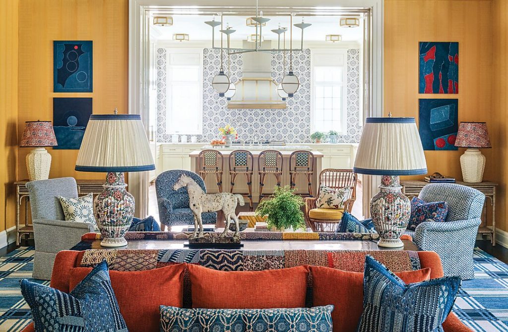 Living room with a coral sectional, blue lamps and painted panels