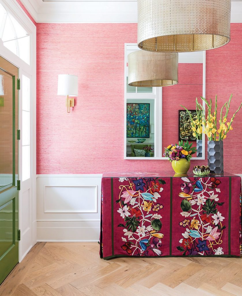 Pink grasscloth entry with a floral-skirted console and drum pendant