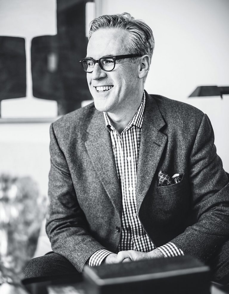 Black-and-white portrait of a man in a tweed jacket