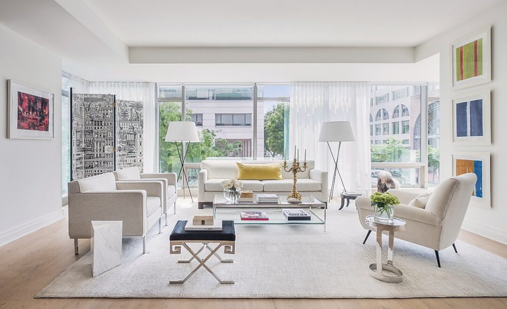 In the living room, collected artwork by Gunther Forg, above right, and Jeremiah Goodman, above left, frame the seating area. The floor-to-ceiling glass walls frame their views of neighboring architecture.