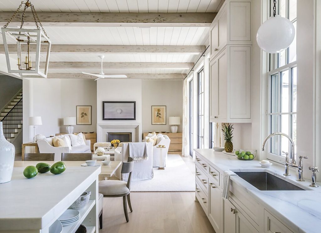 Open white kitchen and living space with lantern pendants