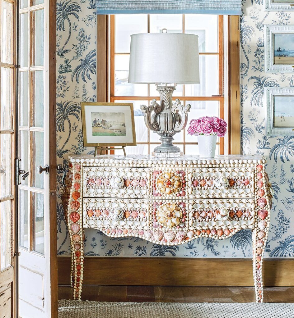 Painted chest with a lamp and framed art between French doors