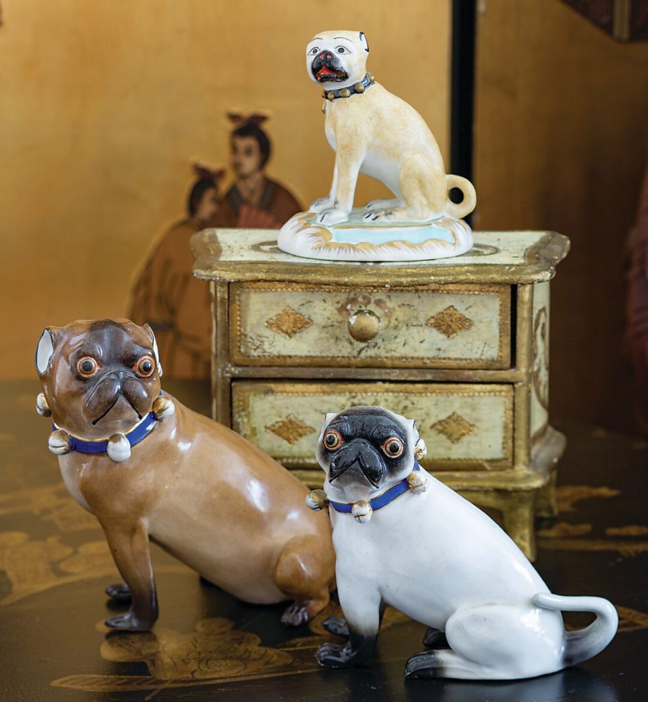 Porcelain dog figurines on and beside a painted bombe chest