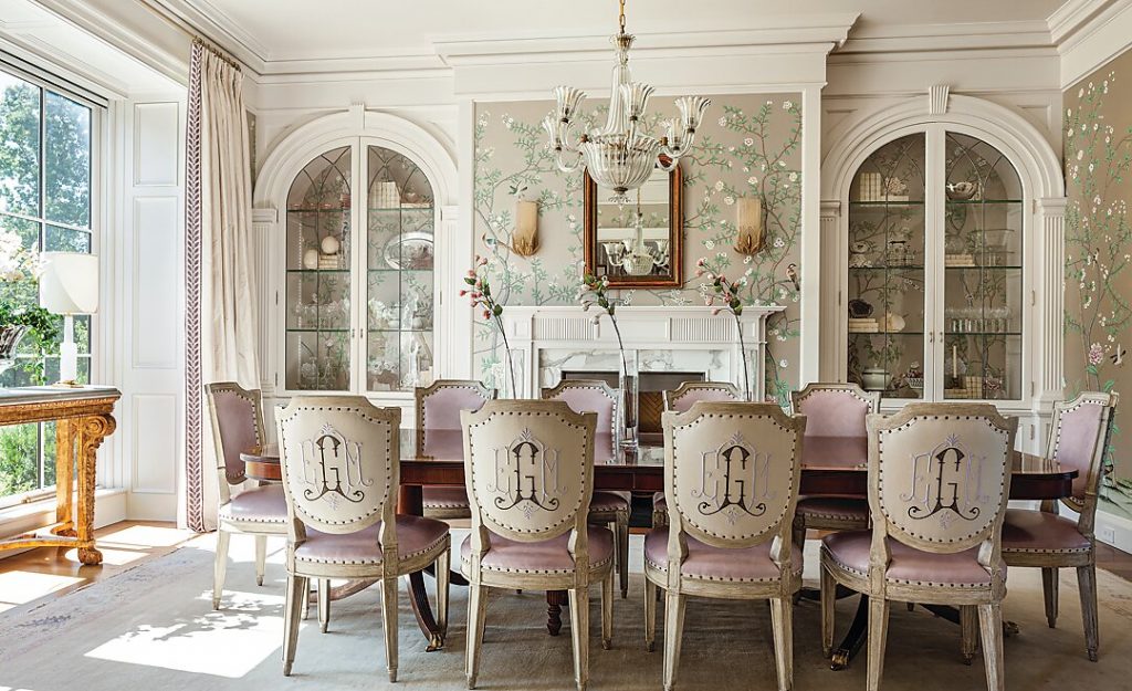 Dining room with grasscloth walls, arched cabinets and monogrammed chairs