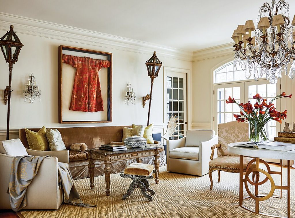 Luxurious élan at play in the living room with glorious antiques, tactile fabrics, and well-edited objets d’art shine against creamy walls in Benjamin Moore’s Linen White and a neutral hued rug.