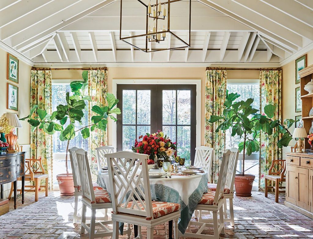 Dining room with a vaulted plank ceiling, floral curtains and a fig tree