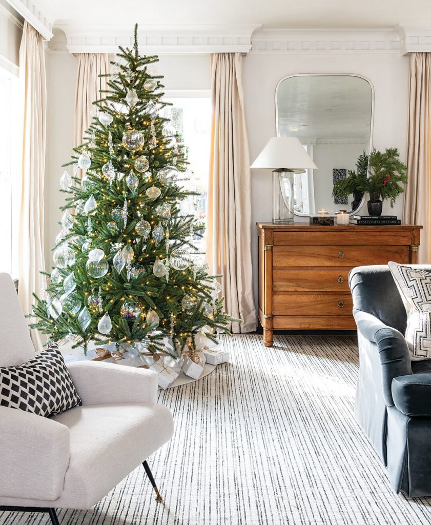Living room with a Christmas tree, walnut chest and striped rug