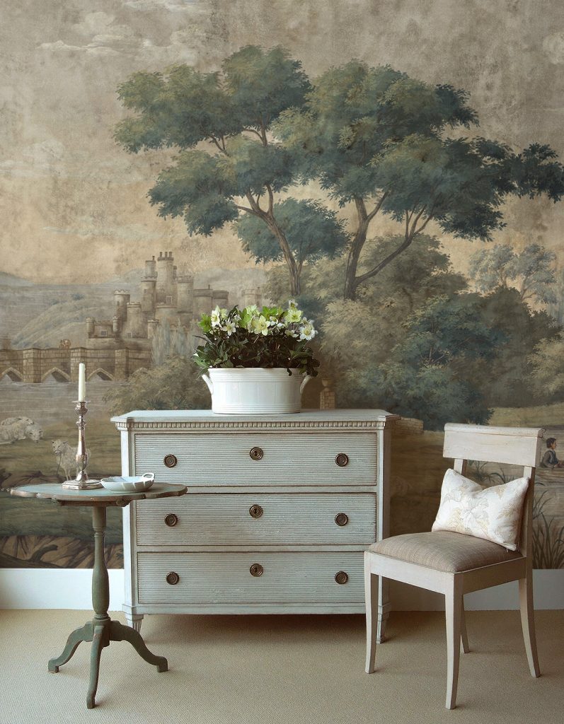 Painted chest and chair against a pastoral landscape mural